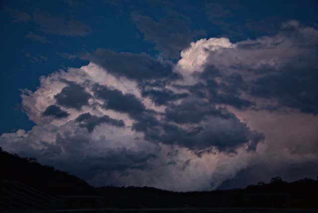 Towering storm clouds lit pink by the setting sun