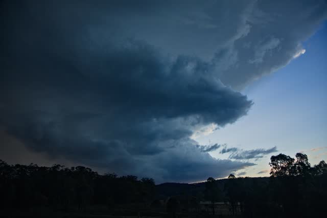 Storm structure silhouetted against a dusk sky